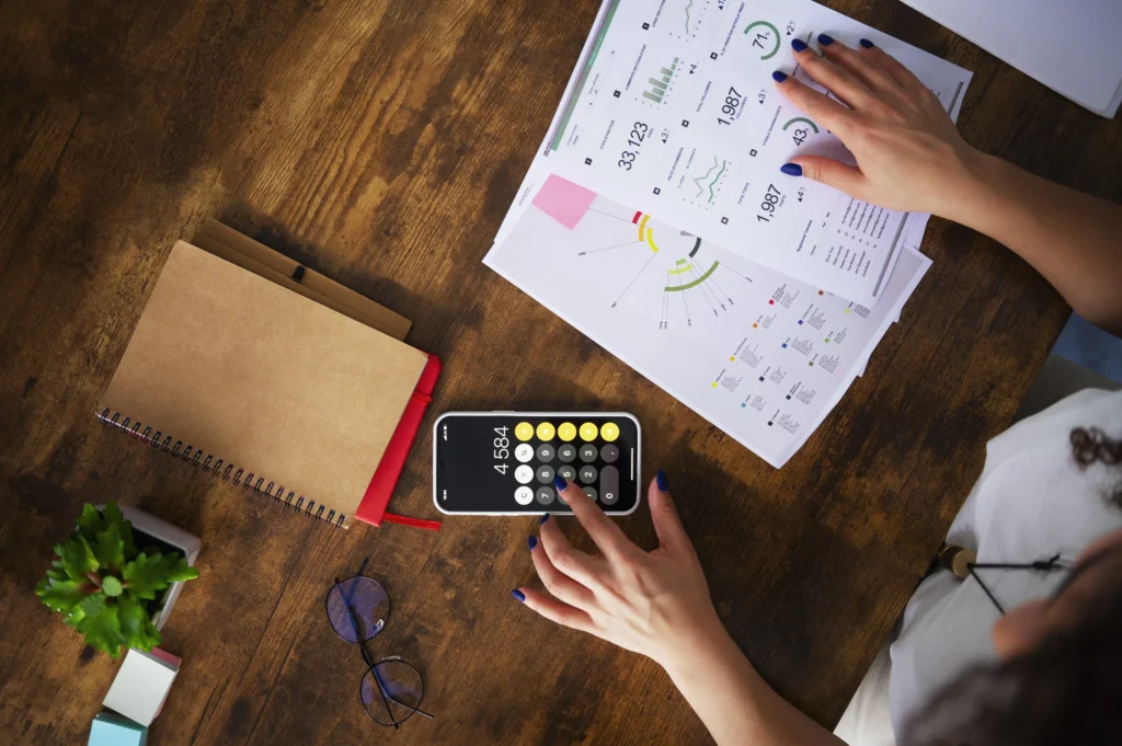 Overhead view of financial reports and a calculator on a desk, representing analysis and planning for React.js Cost Savings in enterprise budgets.