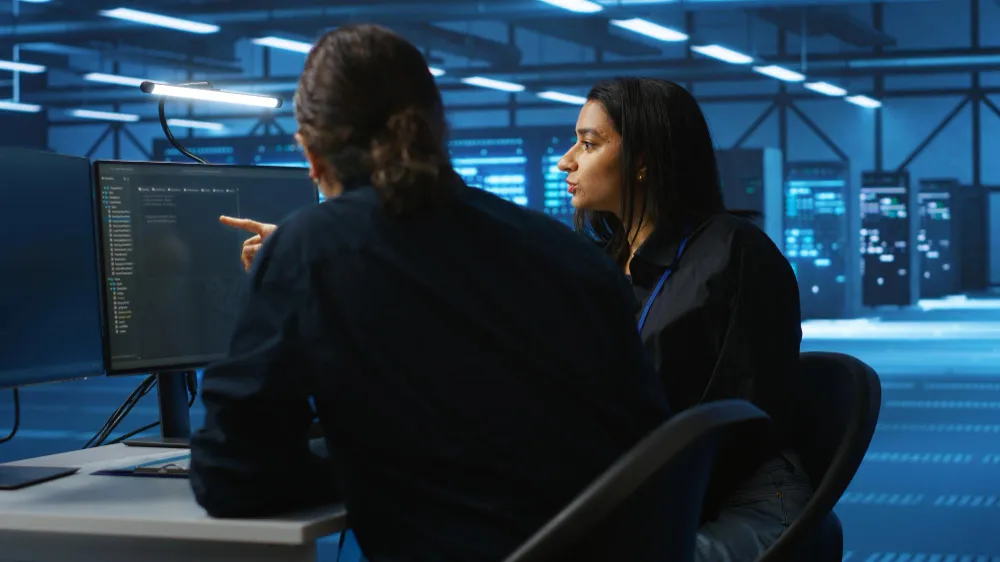 Engineers reviewing code and security systems while planning to Adopt DevSecOps as a Service for secure and scalable software delivery.