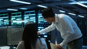 Engineers analyzing systems and data pipelines while comparing DataOps vs DevOps for enterprise automation and infrastructure management.