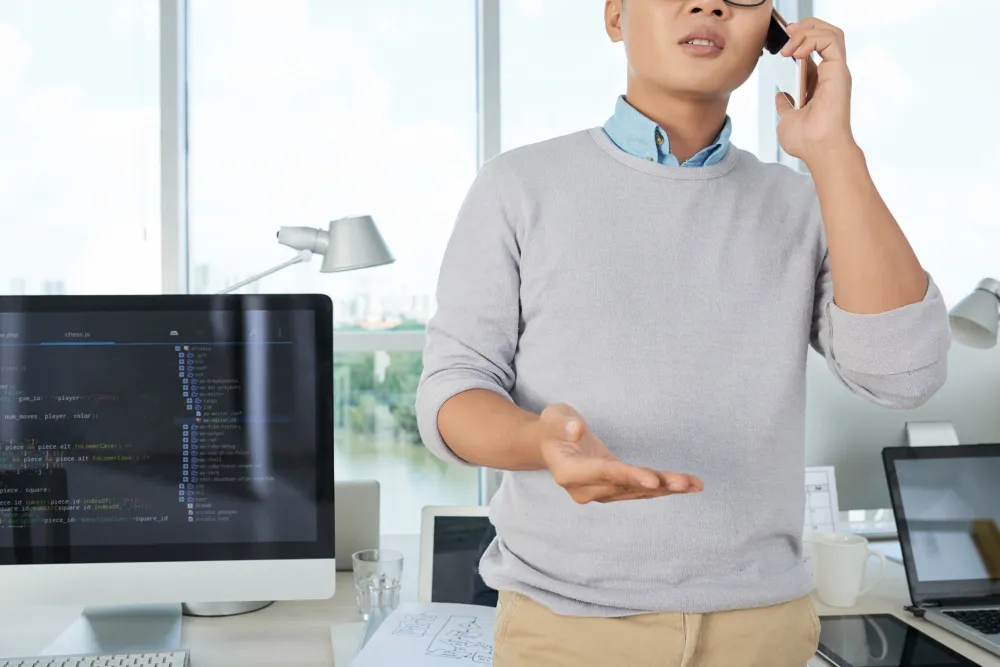 IT professional discussing DevOps as a Service Cost while analyzing development environment and pricing strategies on desktop screens.
